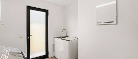 A small, modern kitchen with a built-in sink and a compact refrigerator.