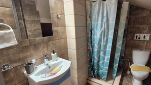 A bathroom with a sink, toilet, and shower curtain.