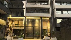 A multi-story building with a modern architectural design, featuring balconies and large windows. - Oceana Suites San Eugenio (Santiago)
