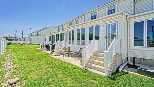 A row of mobile homes with a patio area, outdoor seating, and a staircase leading to the entrance. - The LemonDrop: 3-bedroom townhome in charming Lewes minutes away from Beaches! (Lewes)