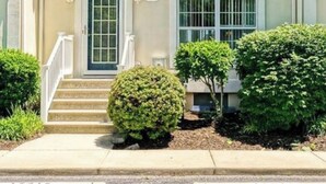 A two-story residential building with a front entrance, a small porch, and a mailbox. - The LemonDrop: 3-bedroom townhome in charming Lewes minutes away from Beaches! (Lewes)