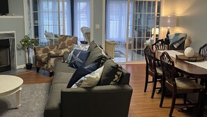 A living room with a sofa, dining table, chairs, and a fireplace. - The LemonDrop: 3-bedroom townhome in charming Lewes minutes away from Beaches! (Lewes)