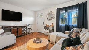 Una sala de estar con sofá, mesa de centro y televisión.
