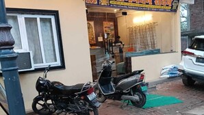 Ein Gebäude mit einer Schautafel und einem abgestellten Motorrad.