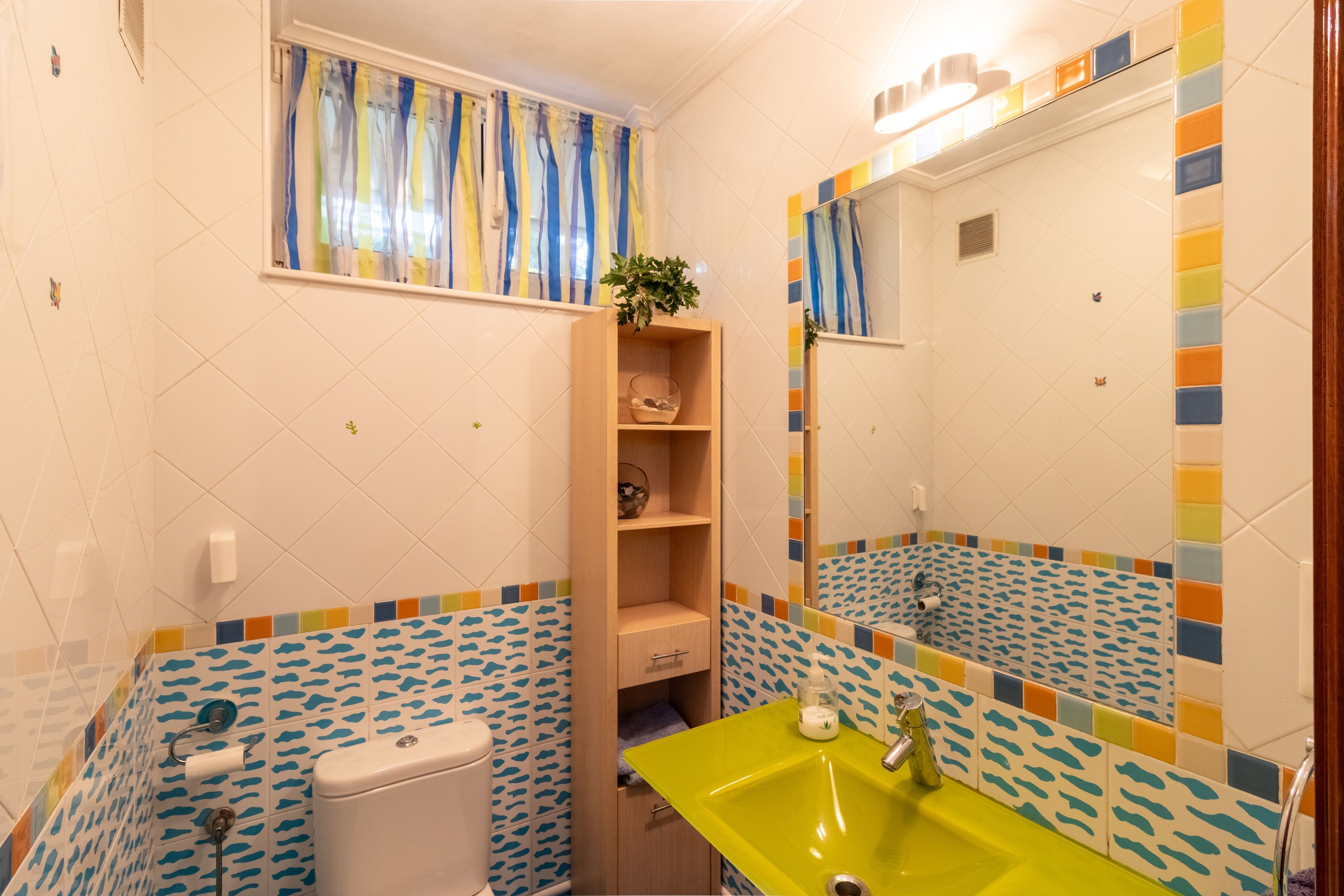 Un baño con inodoro, lavabo y espejo.