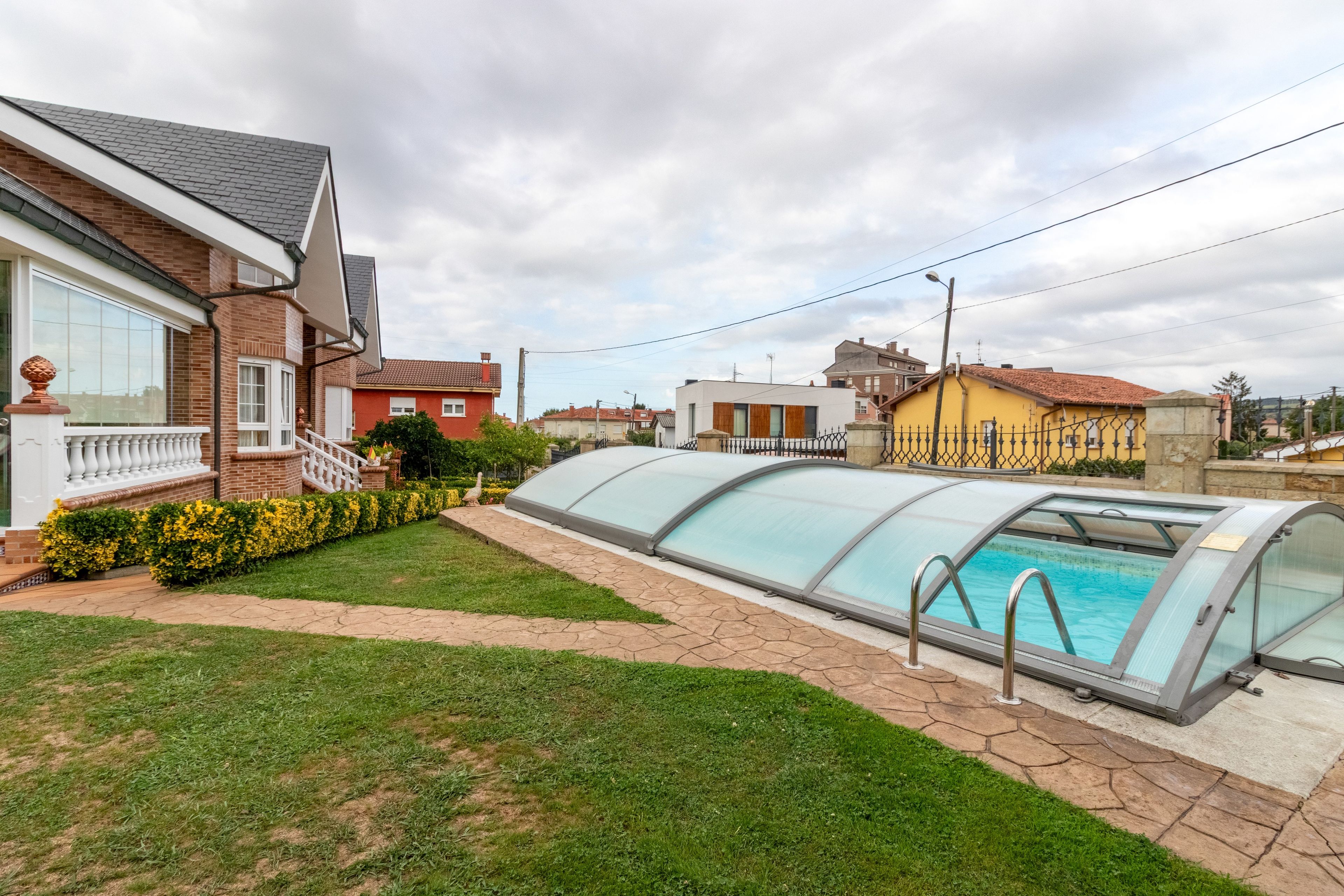Una zona residencial con piscina, patio cubierto y diversas viviendas.