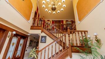 Un magnifique escalier avec des balustrades en bois et un lustre.