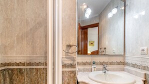 A bathroom with a marble sink, a mirror, and a shower area. - 'Alojamientos Marte Room 2' with Shared Terrace and Garden (Torrelavega)