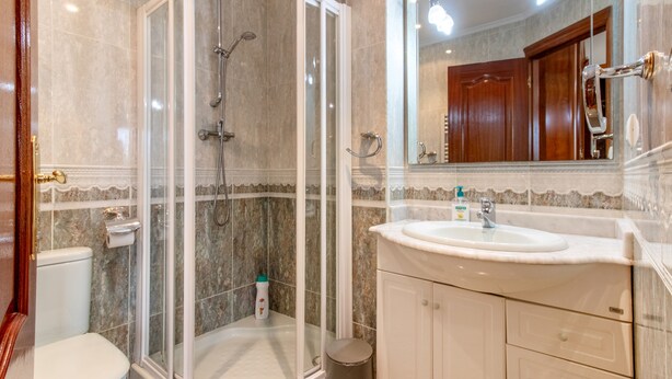 A bathroom with a glass-enclosed shower, a sink, and a toilet. - 'Alojamientos Marte Room 2' with Shared Terrace and Garden (Torrelavega)