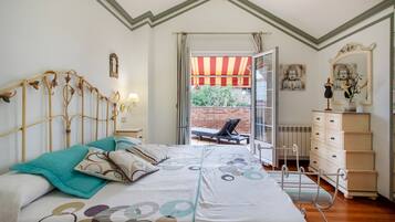 Une chambre à coucher avec un lit, une commode, une chaise et une vue sur l’extérieur.