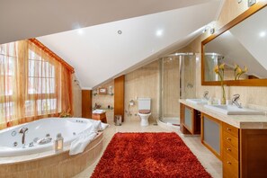 Ein modernes Badezimmer mit einer großen Badewanne, einer begehbaren Dusche und einem Waschtisch mit Spiegel.