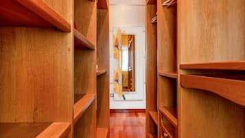 Ein Korridor mit Holzausbau, eingebauten Regalen und einer Tür am Ende.