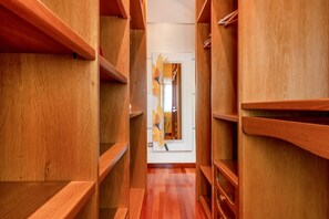 A wooden interior corridor with built-in shelving units and a door at the end.