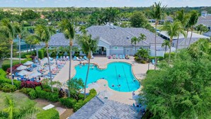 Ein Resort mit Swimmingpool, umgeben von Palmen und Liegestühlen.