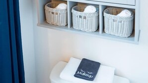 A bathroom with a white cabinet containing wicker baskets and a white sink with a towel labeled "Makeup". - Hyland Suite 103, Hyland Hotel (Palmer)