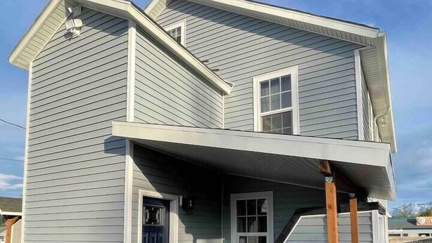 A two-story house with a front porch and a small deck. - Hyland Suite 103, Hyland Hotel (Palmer)