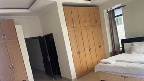 Une chambre comprenant un lit, une armoire et un petit coin salon.