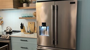 A stainless steel refrigerator with a water dispenser, a light blue cabinet, and a wooden countertop with kitchen utensils. - Beautiful Sandy Lake Cabin (as seen on HGTV) (Trent Lakes)