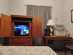 Espacio para trabajar con laptop y tabla de planchar con plancha