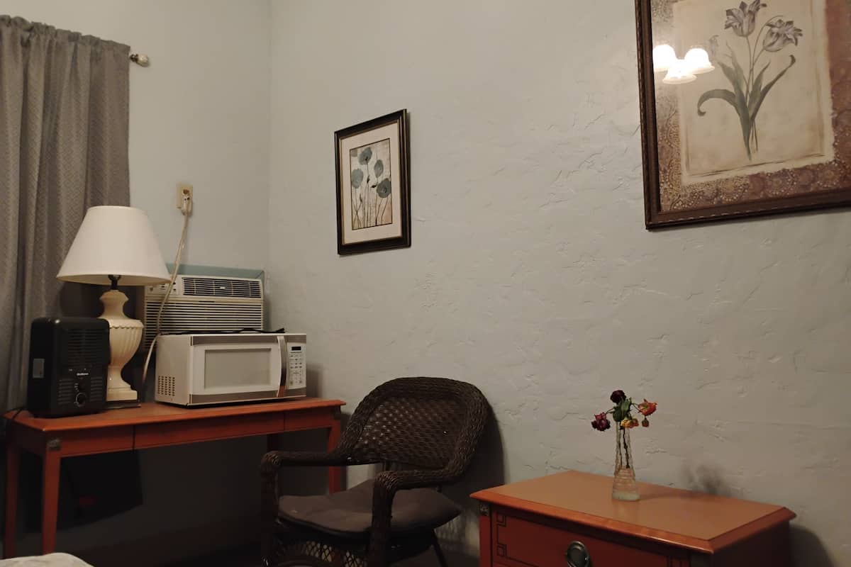 Espacio para trabajar con laptop y tabla de planchar con plancha