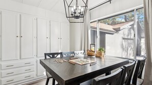 A dining area with a dark wooden table, white cabinets, and a chandelier. - Charming Pines Cabin / Fireplace + BBQ Retreat (Show Low)