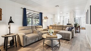 A modern living room with a sectional sofa, a round coffee table, and a lamp. - Charming Pines Cabin / Fireplace + BBQ Retreat (Show Low)