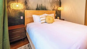 A bedroom with a wooden headboard, white bedding, and two wall-mounted lamps. - Quiet/New 2bd Suite w/ Laundry, Kitchen, Wi-Fi (Palmer)