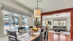 A dining area with a wooden table, chairs, and a hanging light fixture. - Hot Tub w/ Mt Views, Full Kitchen, Laundry (Palmer)