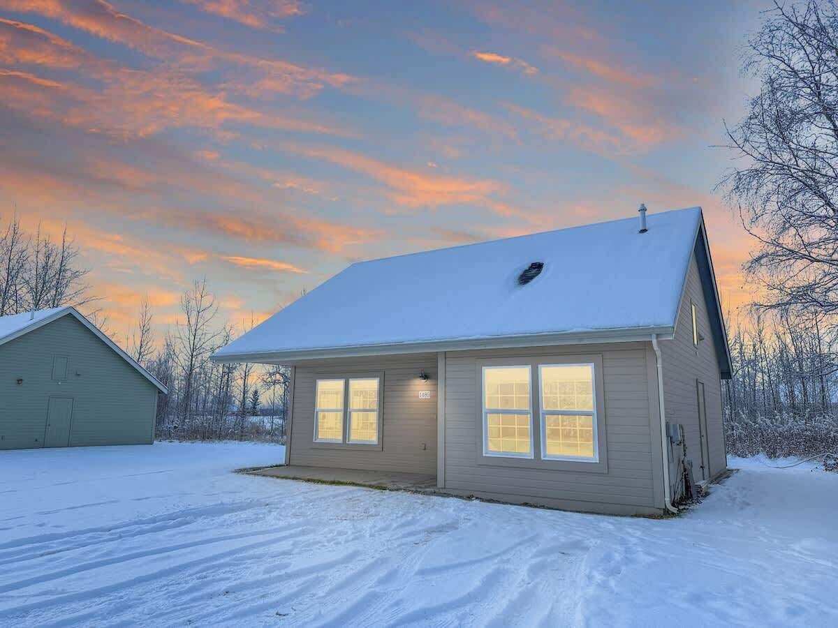A single-story house with a snow-covered roof and a garage attached to the left.