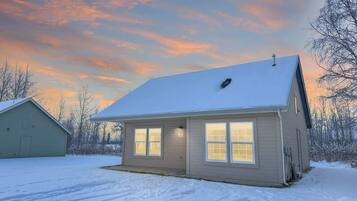 A single-story house with a snow-covered roof and a garage attached to the left.