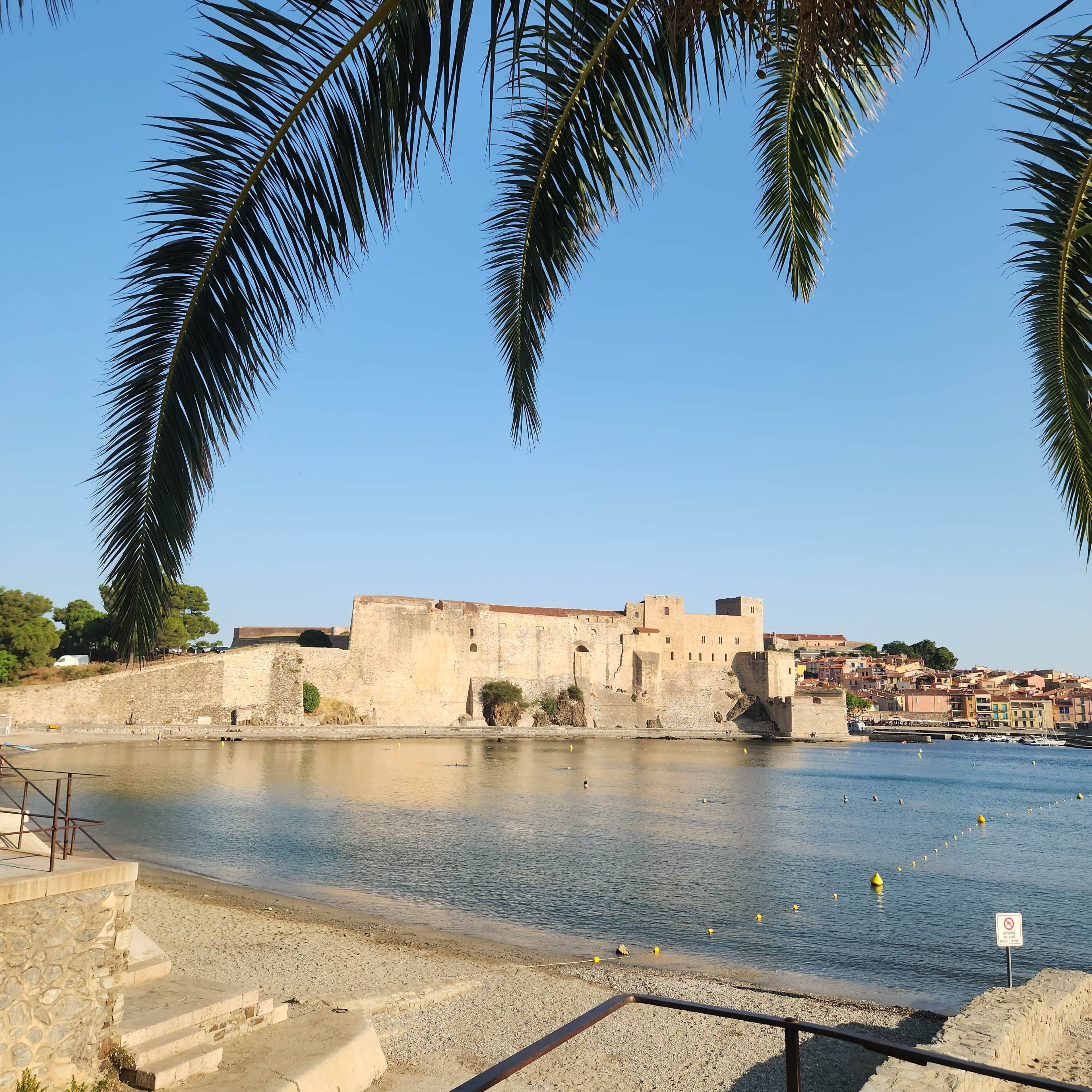 Une vue sur la côte, avec un ancien mur de pierre et un ciel bleu dégagé.