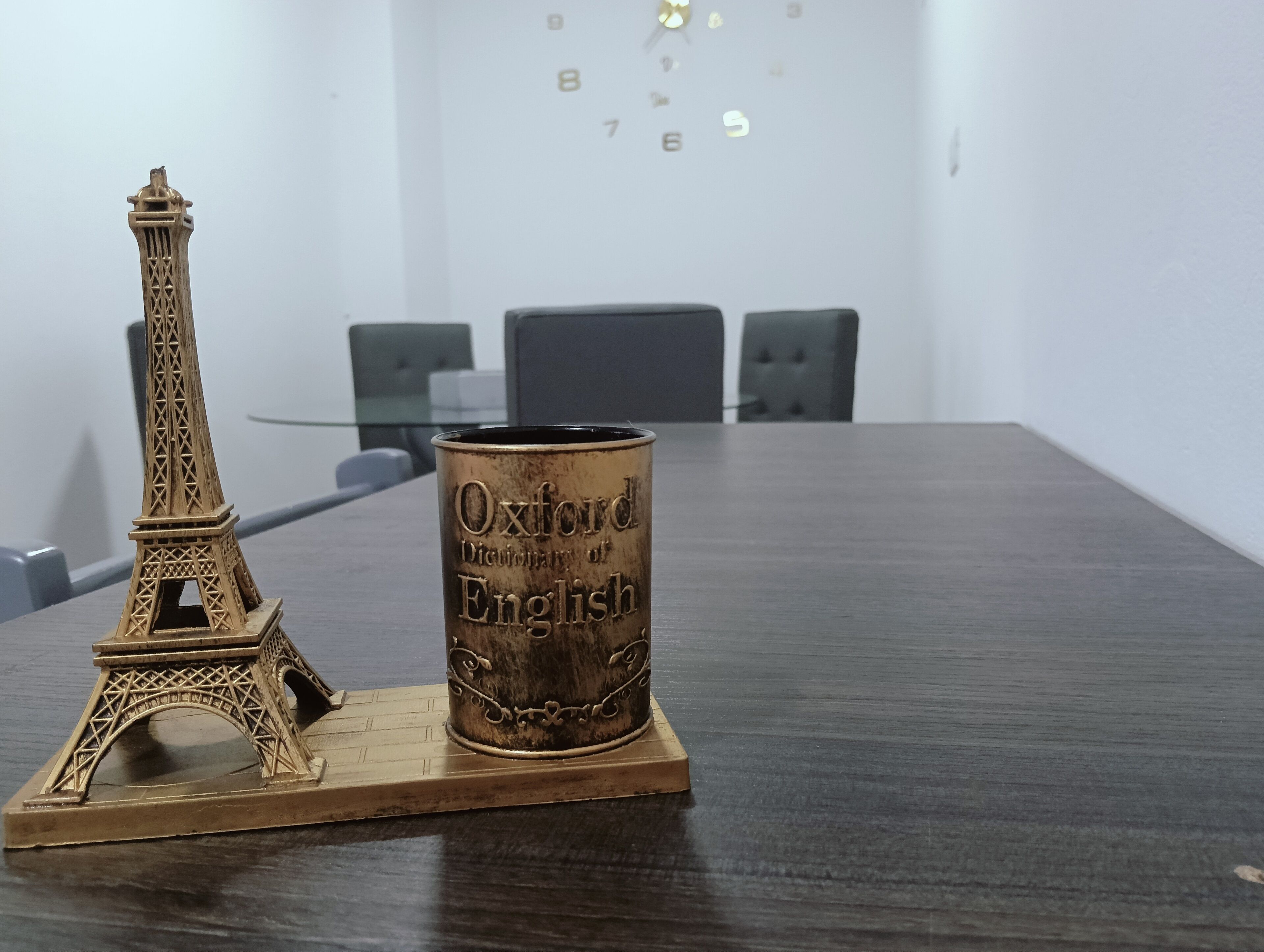 Une maquette de la tour Eiffel et un dictionnaire anglais-français de la collection Oxford sont posés sur une table dans une salle de conférence.