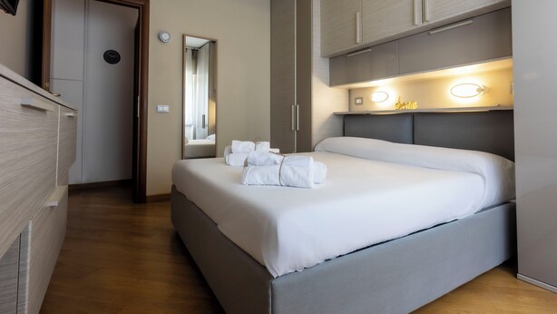 A modern hotel room with a large bed, a wardrobe, and a mirror. - Acasadigiò B&B - 400 meters from the Metro stop and 15 minutes from the center of Rome (Roma)