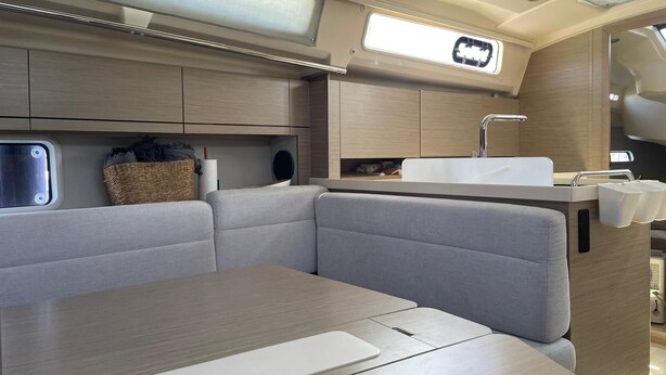A compact galley with a sink, storage cabinets, and a window.