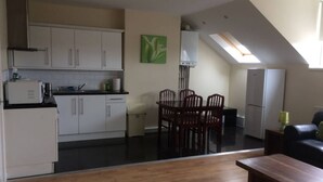A compact living space with a kitchen, dining area, and a small seating area with a bench.