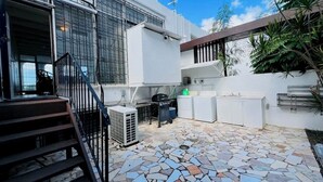 A modern house with a tiled patio, a staircase, and a small outdoor kitchen area. - Enjoy Passport to Paradise! (Christiansted)