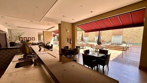 Un hall d’entrée spacieux avec un comptoir d’accueil, un espace salon et une vue sur la piscine extérieure.