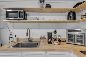 Eine Küche mit eingebauter Mikrowelle, Kaffeemaschine und einem Doppelbackofen.