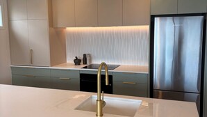 A modern kitchen with a central island, stainless steel appliances, and a minimalist design.