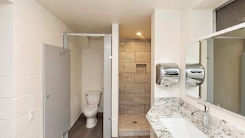 Un baño con inodoro, ducha y lavamanos.