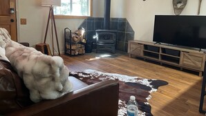 A living room with a fireplace, a television, and a leather sofa.