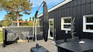 An outdoor patio with a covered table and chairs, a vacuum cleaner, and a covered grill. - Nice home in Slagelse with WiFi (Slagelse)