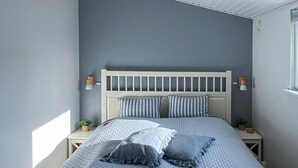 A bedroom with a bed, two bedside tables, a headboard, and two wall-mounted lamps. - Nice home in Slagelse with WiFi (Slagelse)