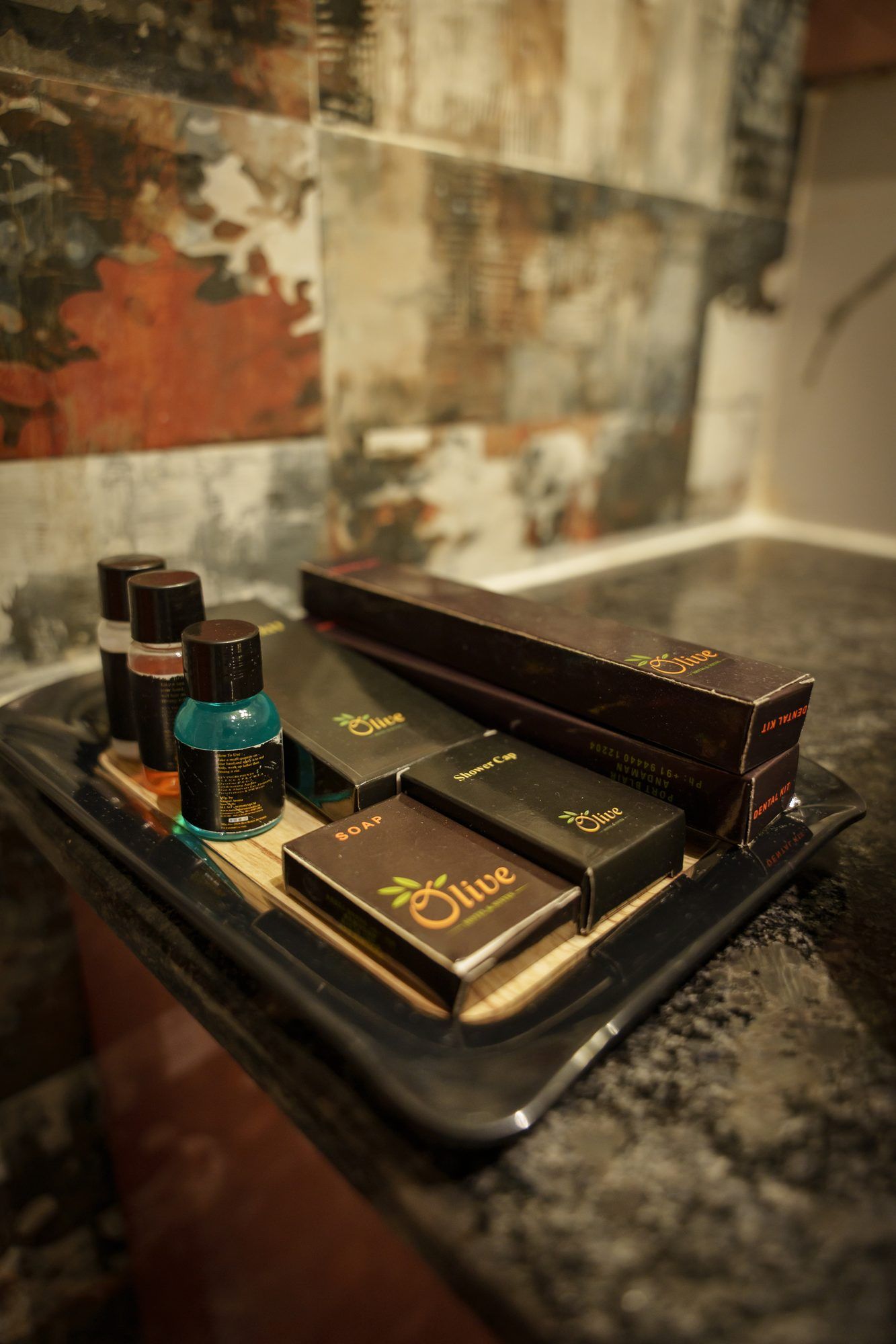 A tray with various toiletries including soap and shampoo, placed on a countertop.