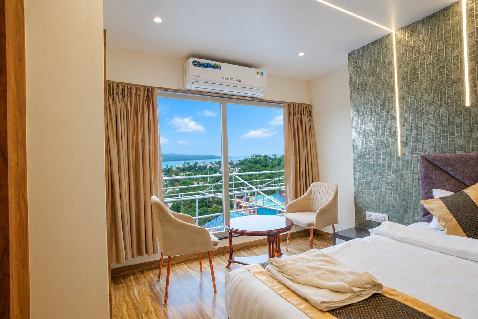 Una habitación de hotel con un ventanal grande, una cama, una mesa redonda y dos sillas.