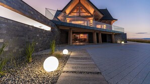 A modern house with a large porch, a stone wall, and a clear sky. - Exclusive Villa for Family, Friends & Workation (Biały Dunajec)