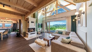 A spacious living room with a fireplace, a large sofa, and a view of the outdoors. - Exclusive Villa for Family, Friends & Workation (Biały Dunajec)