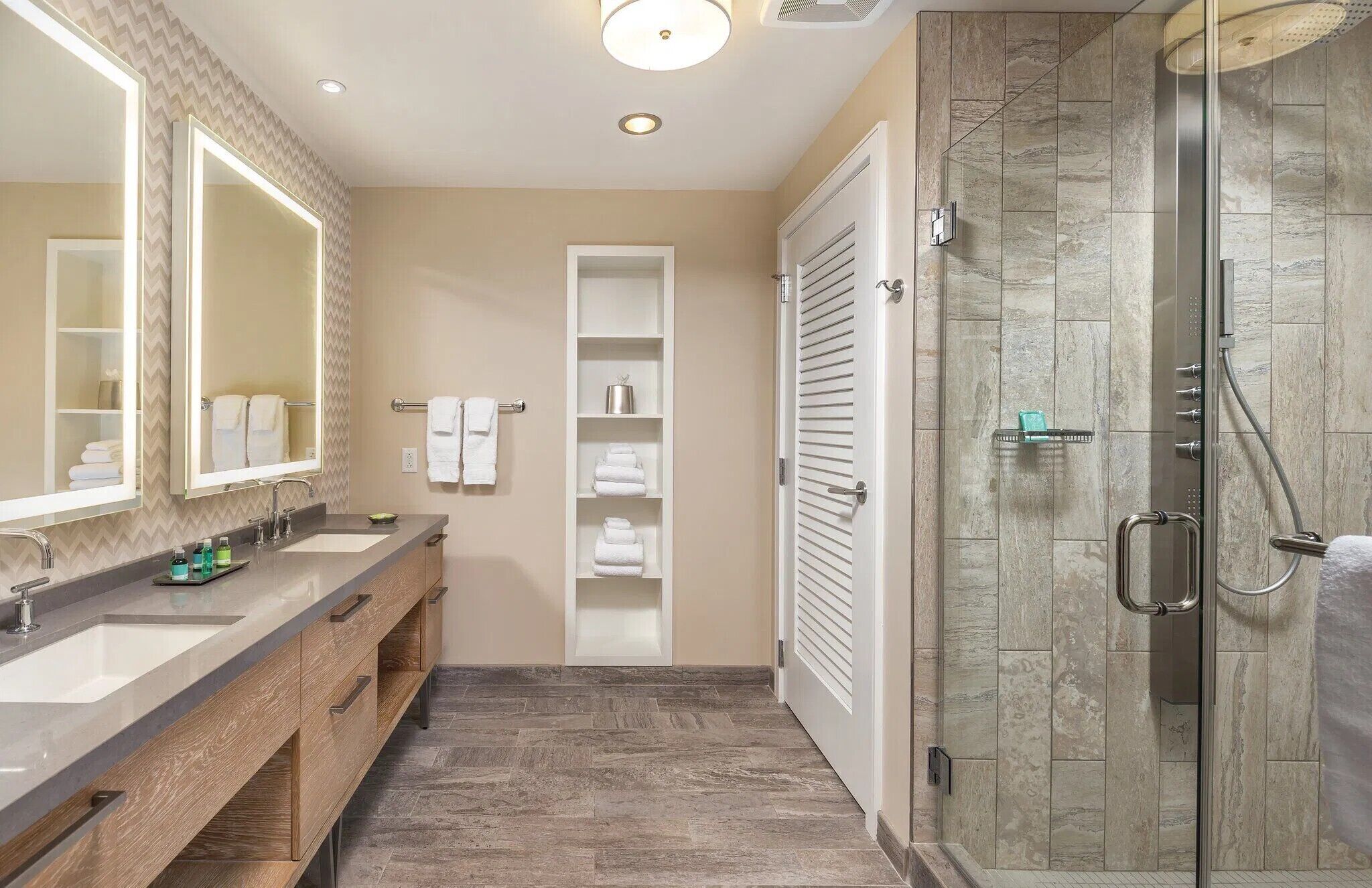 A modern bathroom with a vanity, a glass shower enclosure, and a walk-in shower.