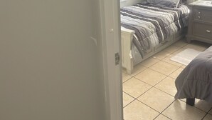 Ein Schlafzimmer mit Bett, Nachttisch und einer Wand mit dekorativem Schild.