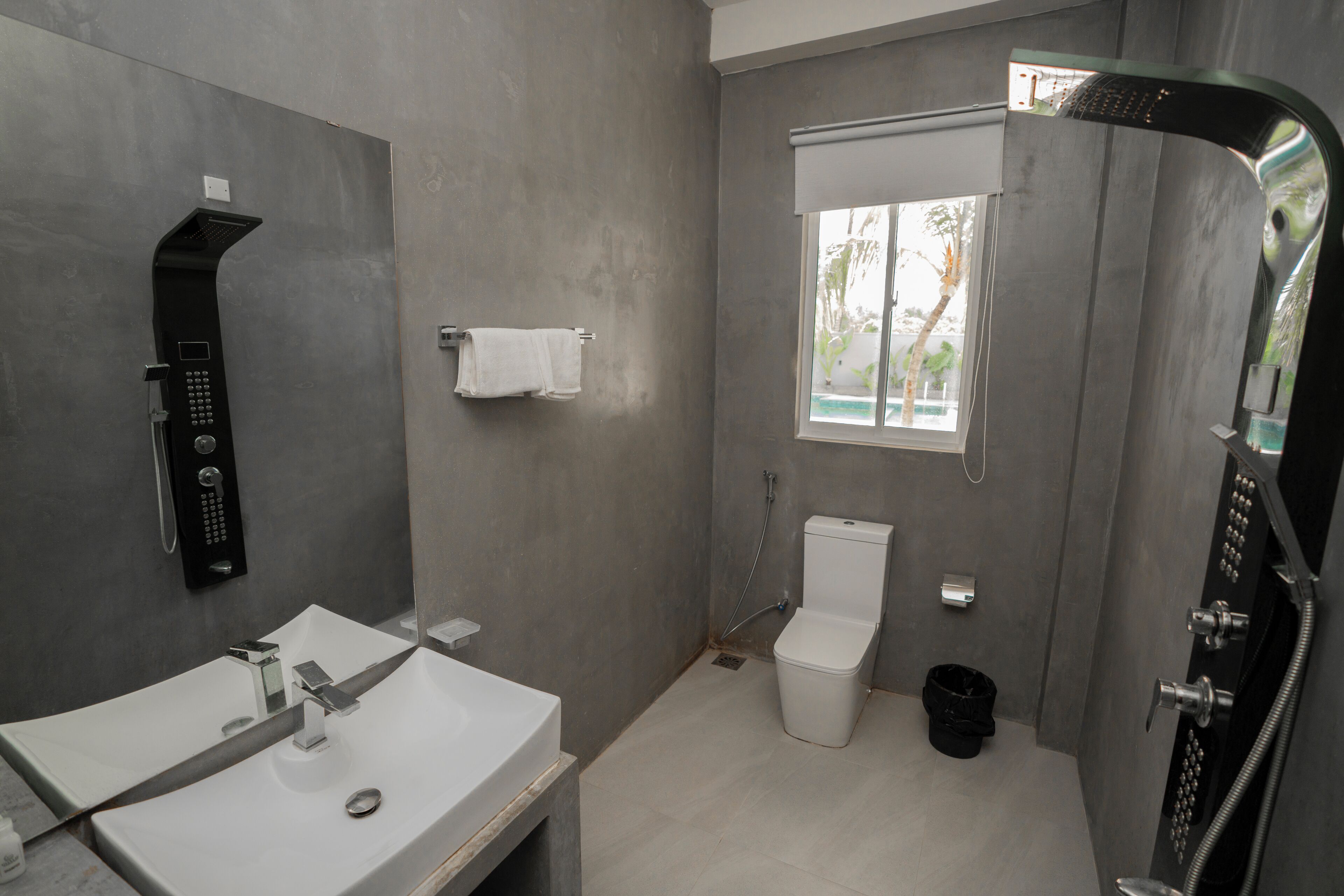 Un bagno moderno con doccia integrata, un water e un lavandino.